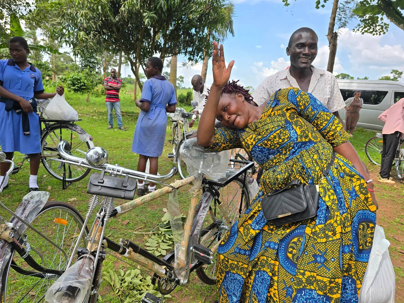 A woman and a man stand beside a bicycle at a community event.