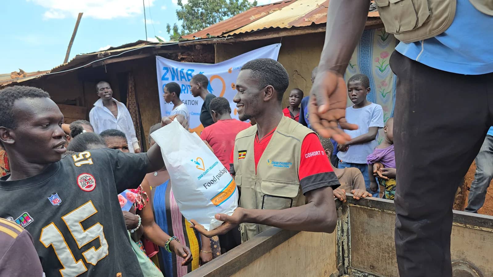 A Zwab team member hands a food package to a community member.