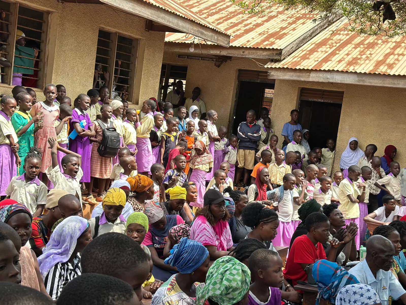 A school community gathers outside a classroom building.