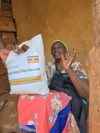 A community member holds a food parcel.