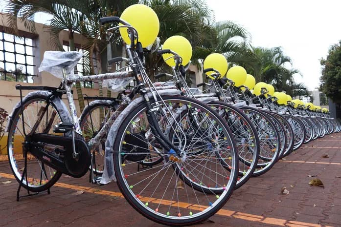Bicycles with yellow balloons are arranged in a row.