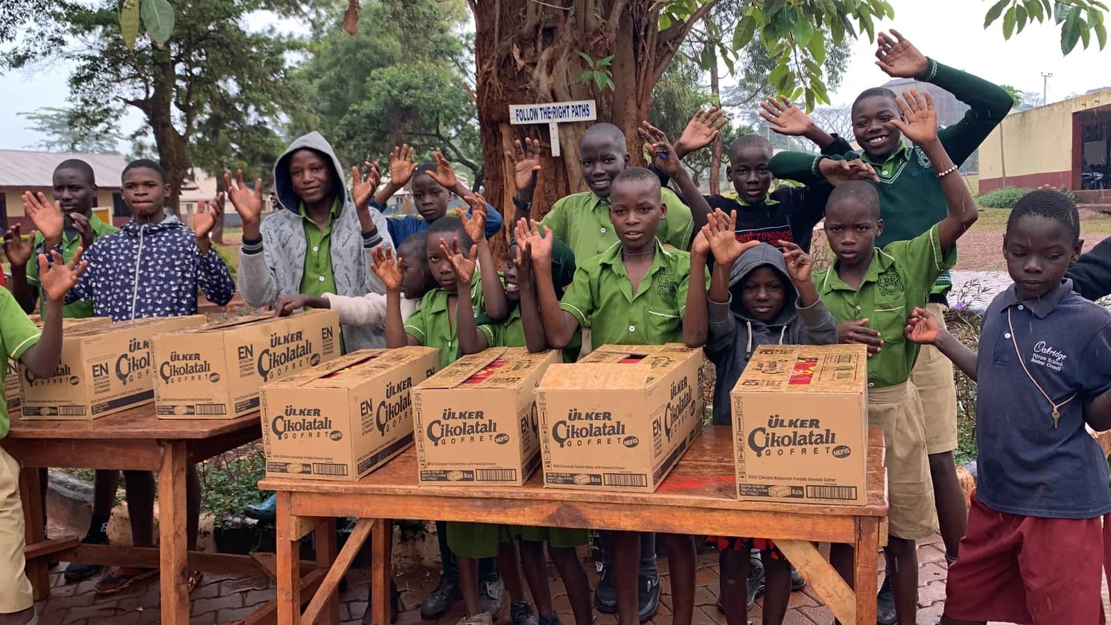 Children gather around boxes at a school community event.