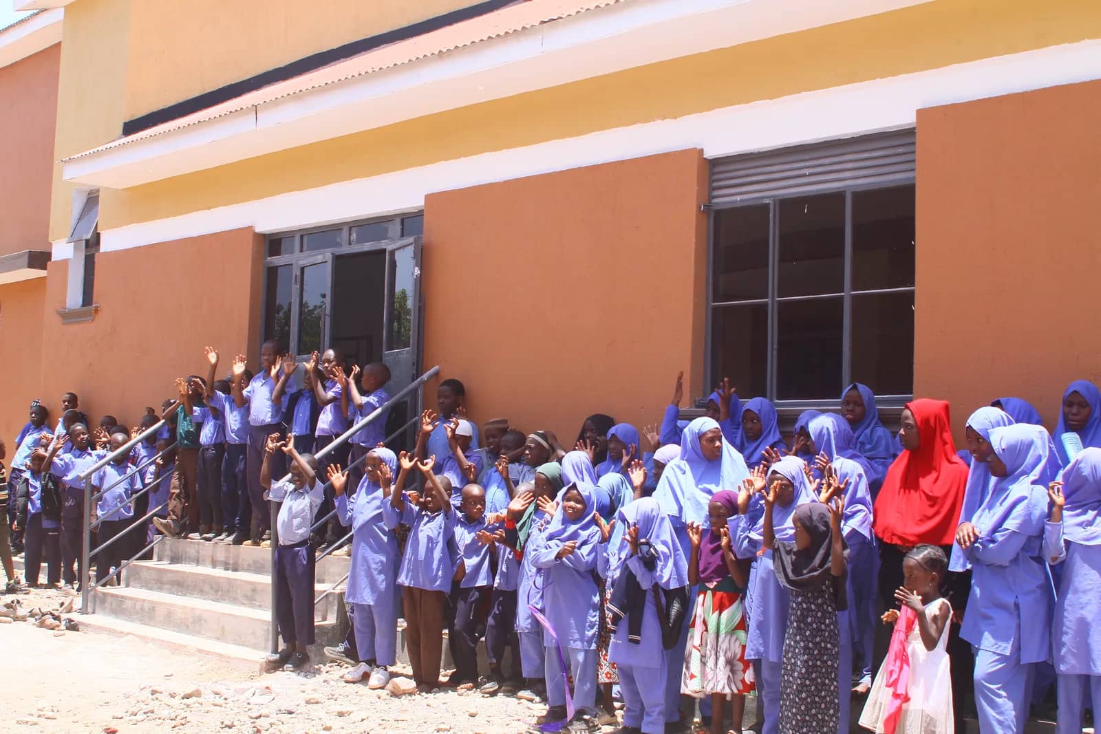 Students gather outside a school building.