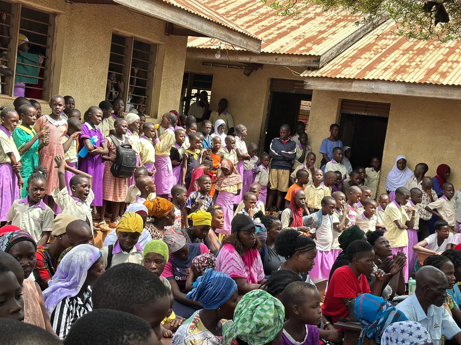 A school community gathers outside a classroom building.